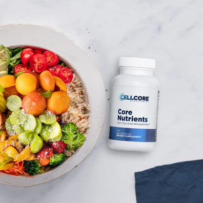 Supplement bottle labeled 'CellCore Core Nutrients' next to a colorful salad on a light background